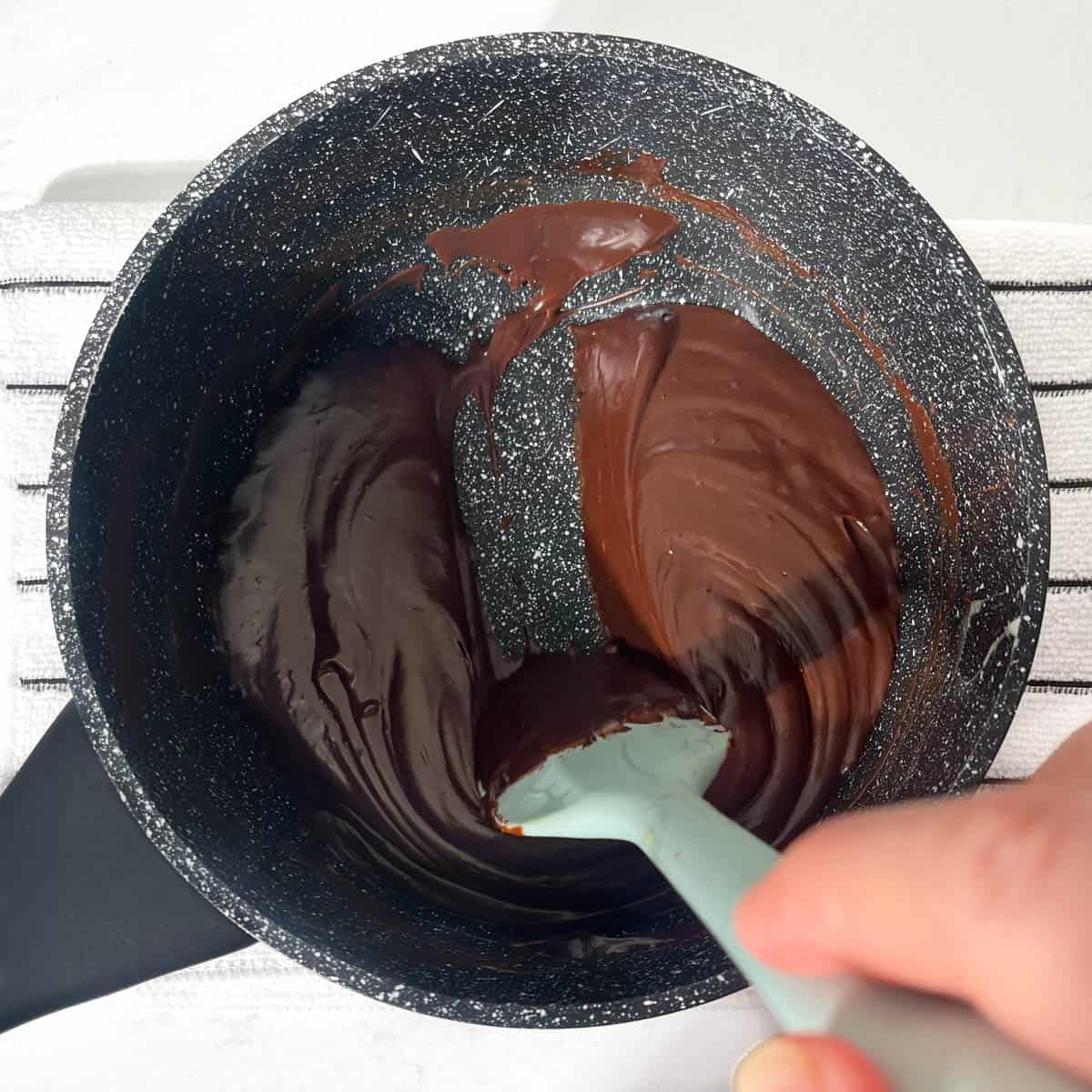 Dragging a spatula through the brigadeiro mixture leaving a thick, clear line on the bottom of the saucepan. 