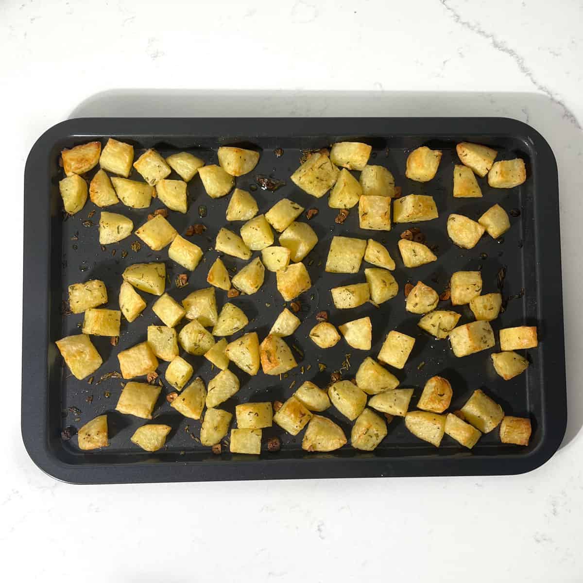 Roasted parmentier potatoes on a baking tray.