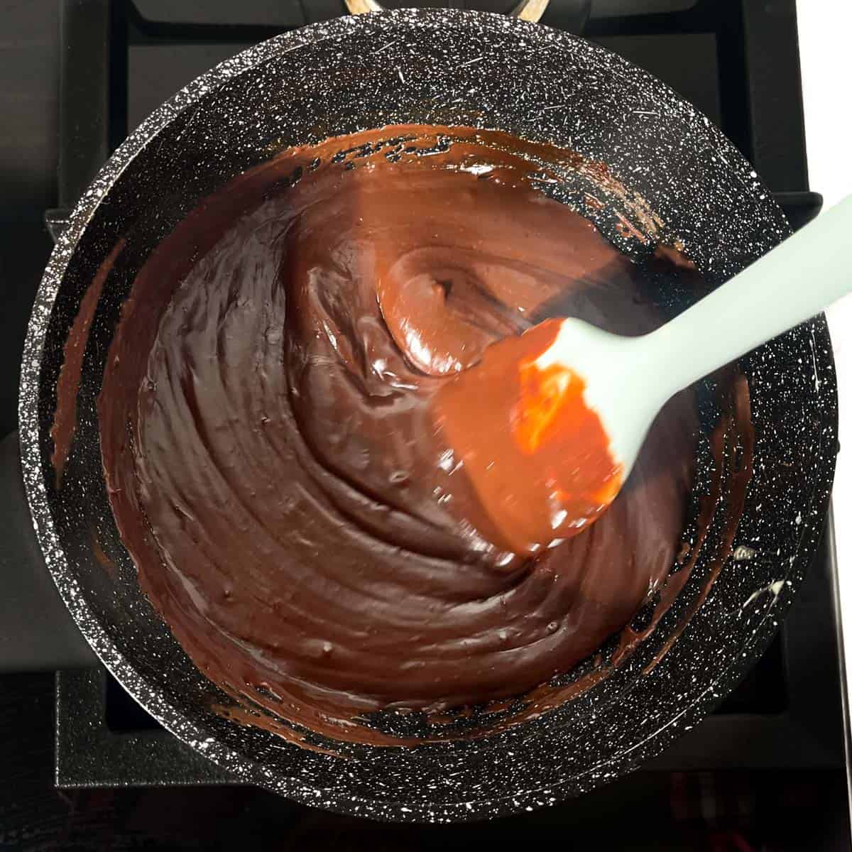 Mixture being stirred until it looks glossy and smooth.