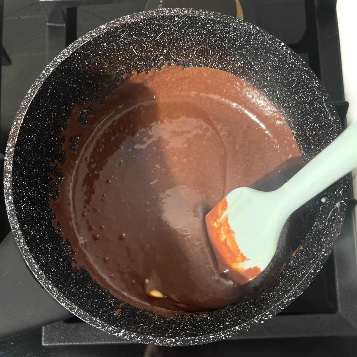 Stirring the brigadeiro mixture to melt the butter.