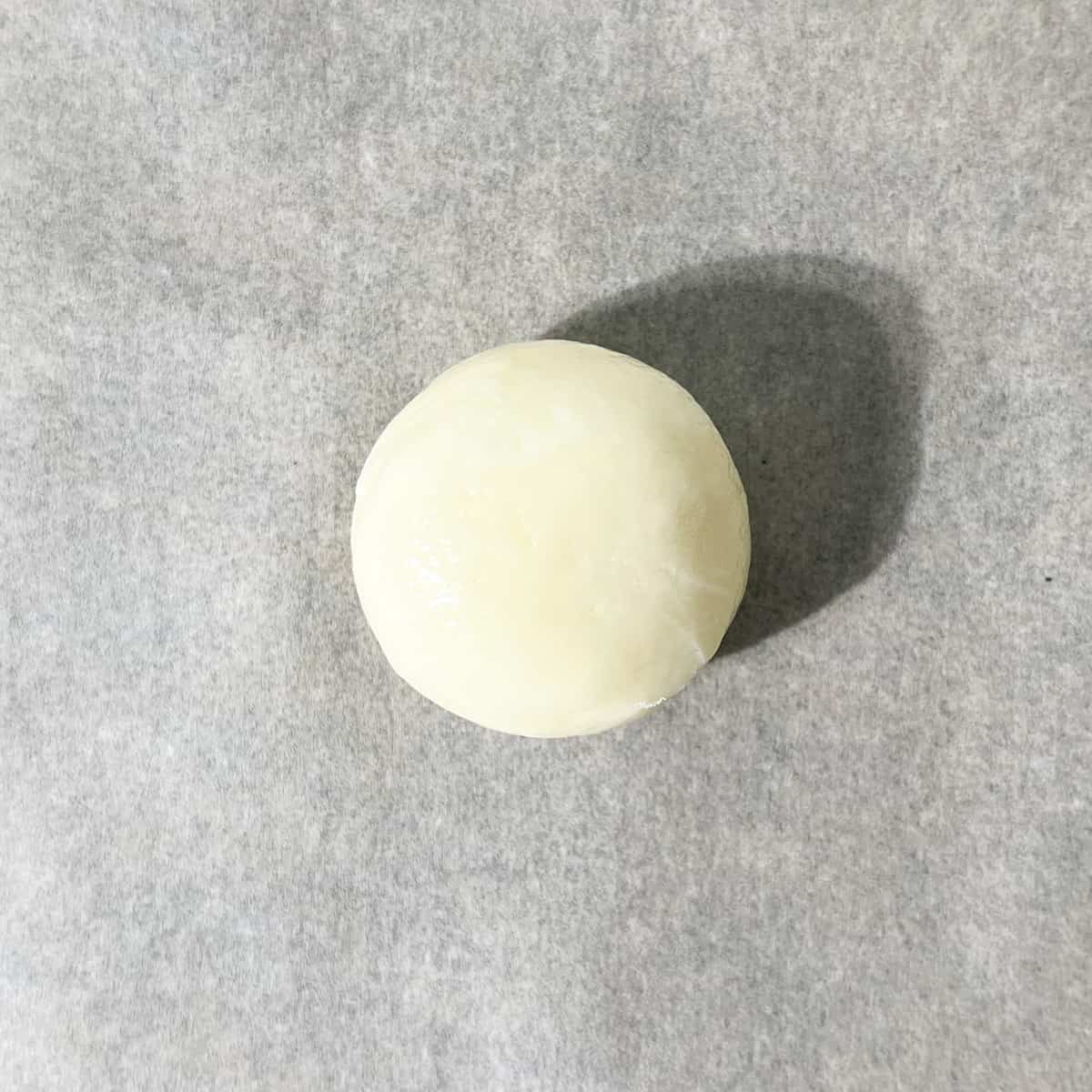 A single dough ball on a baking tray.