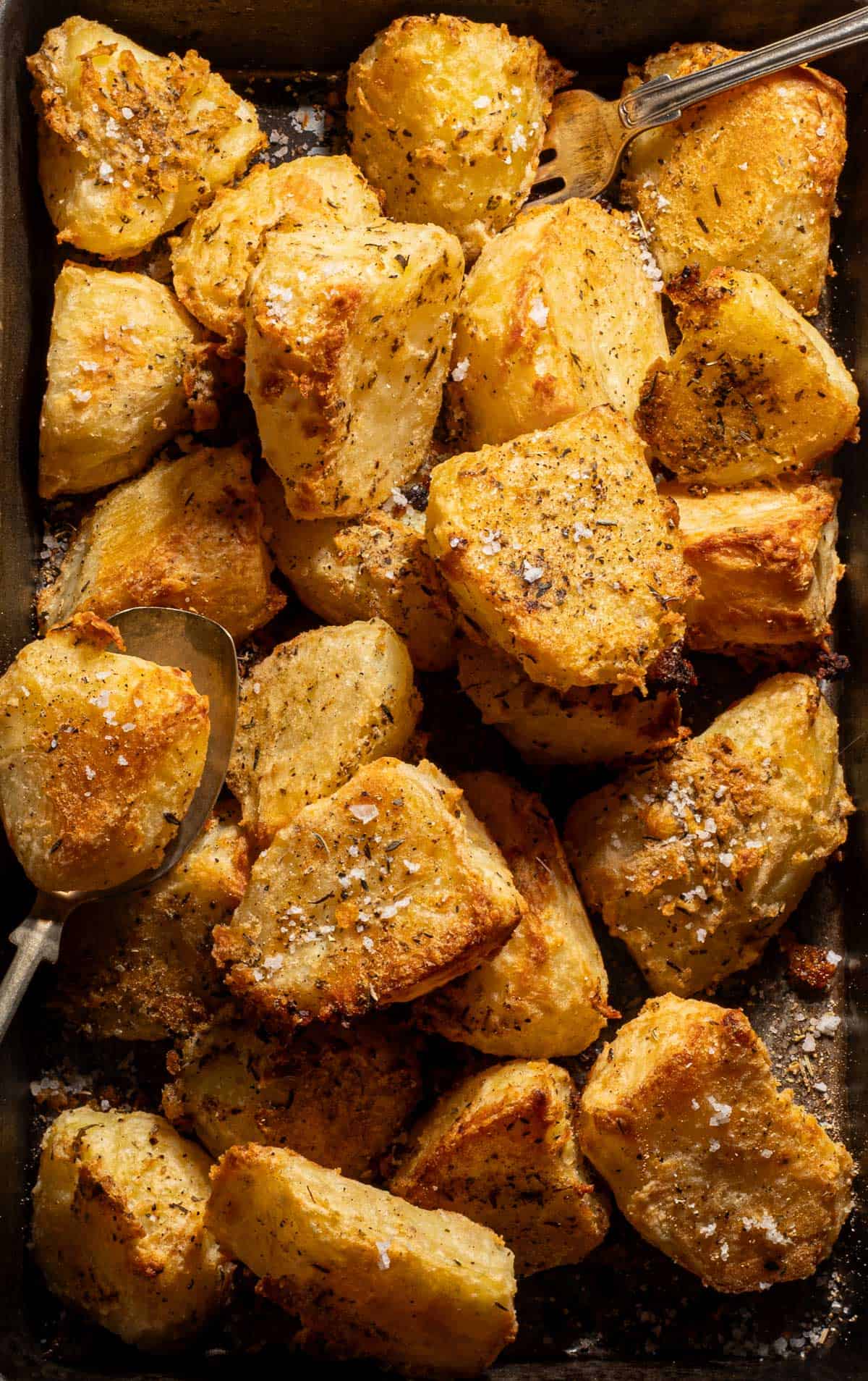 Crispy roasted potatoes on a baking tray.