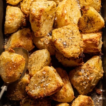 Crispy roasted potatoes on a baking tray.