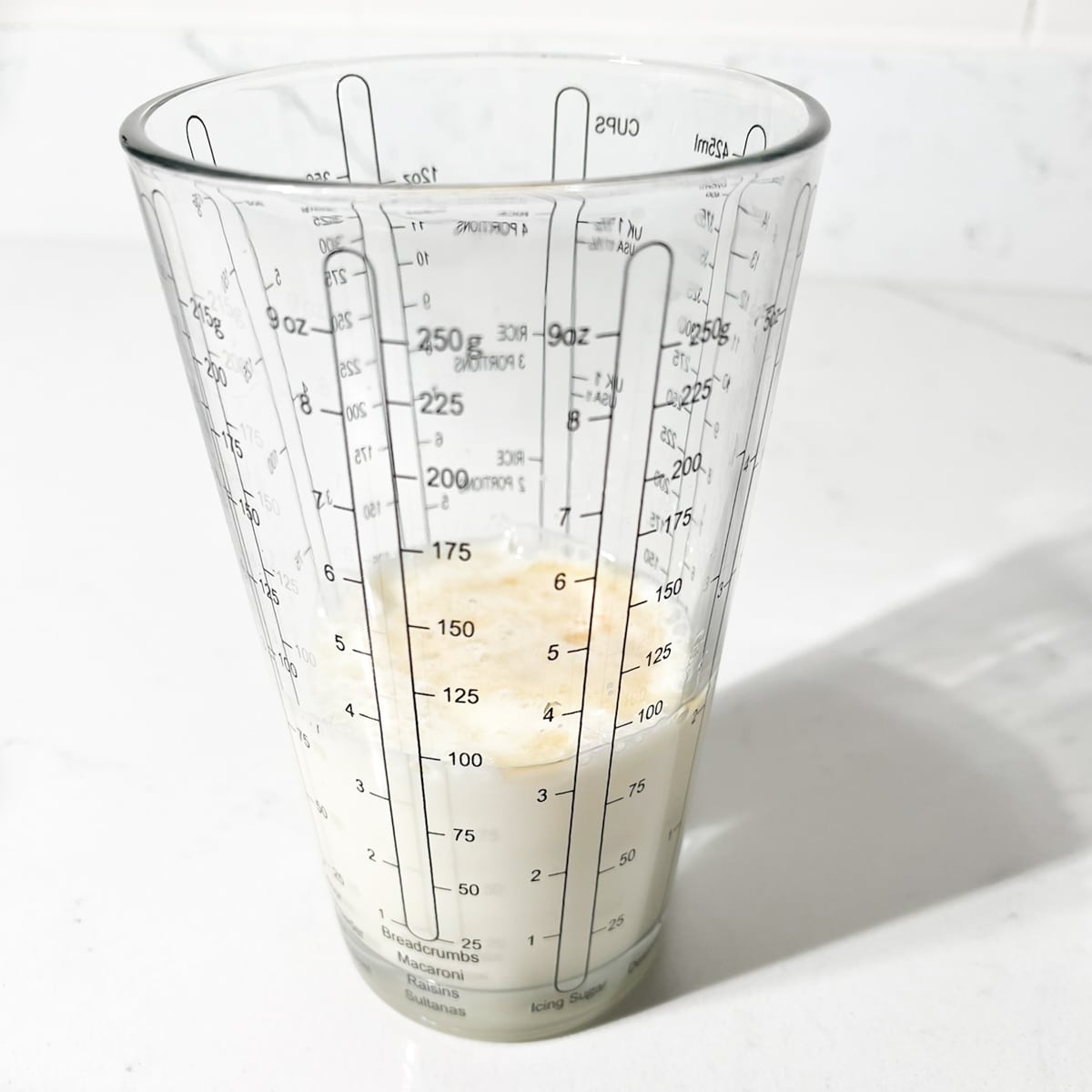 Liquids combine in a measuring cup.