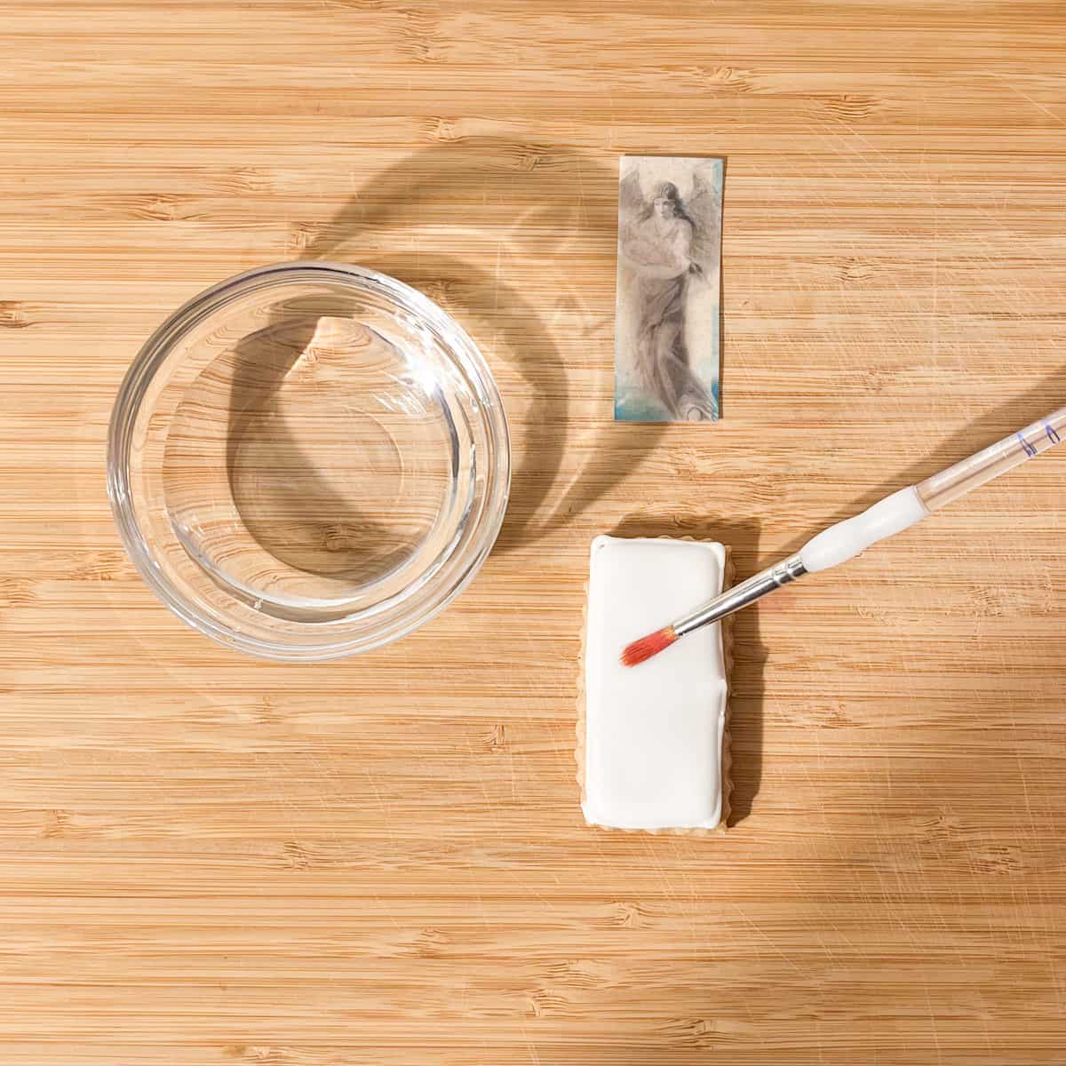 Applying water with a small brush on top of the cookie.