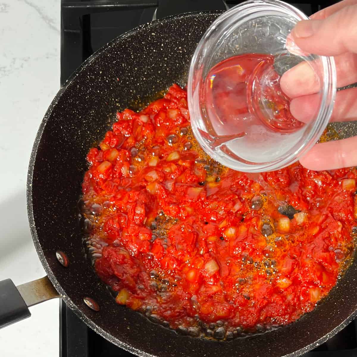 Adding vodka to the Gigi Hadid pasta sauce.