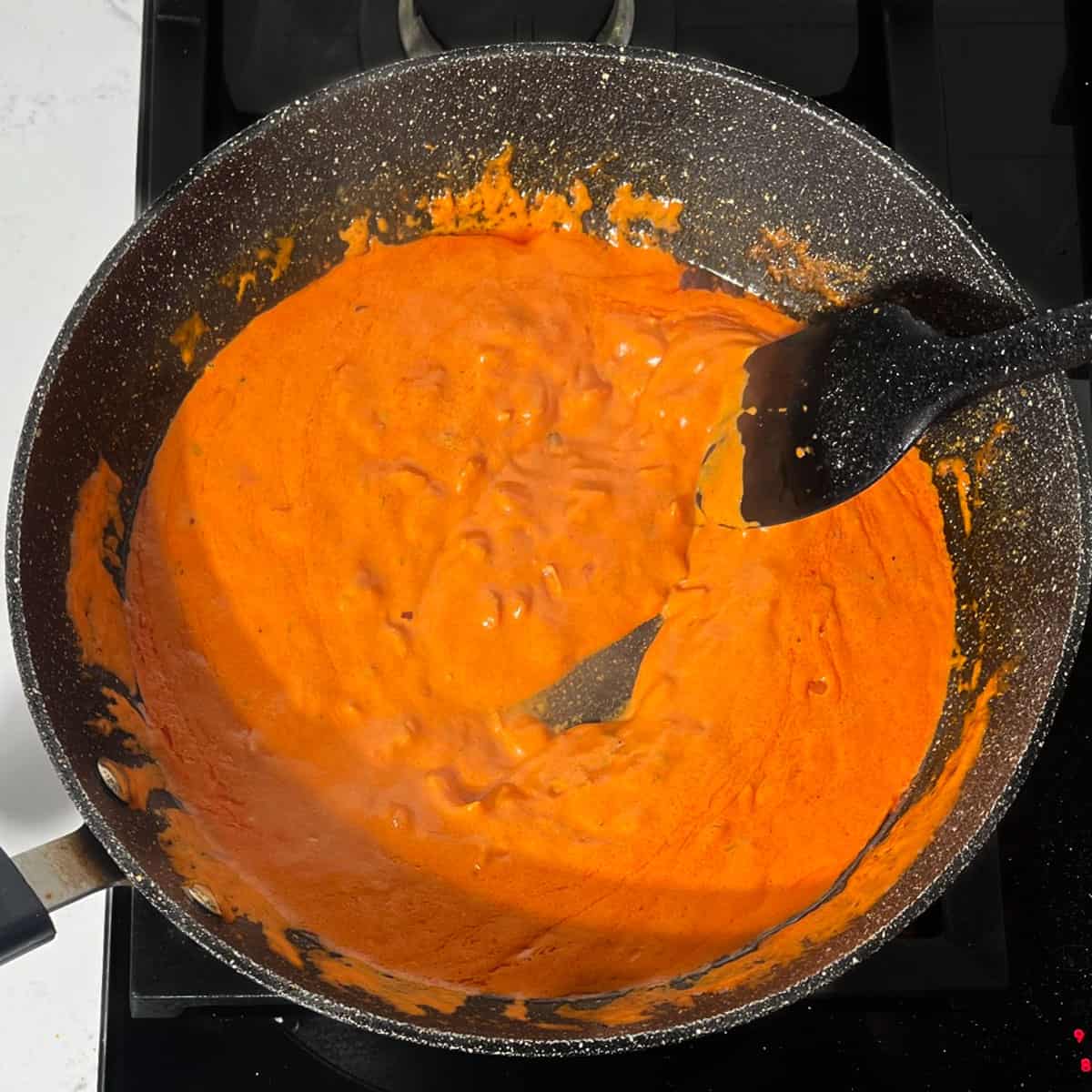 Pasta sauce looking creamy and bright orange.