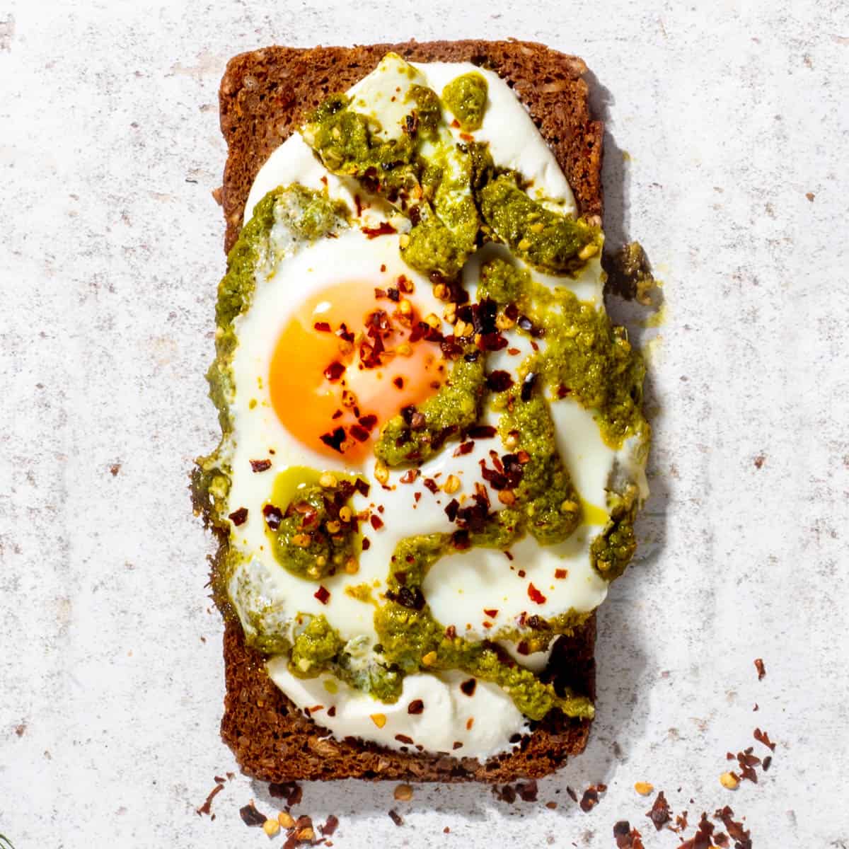Cottage cheese toast with fried egg and pesto topping.