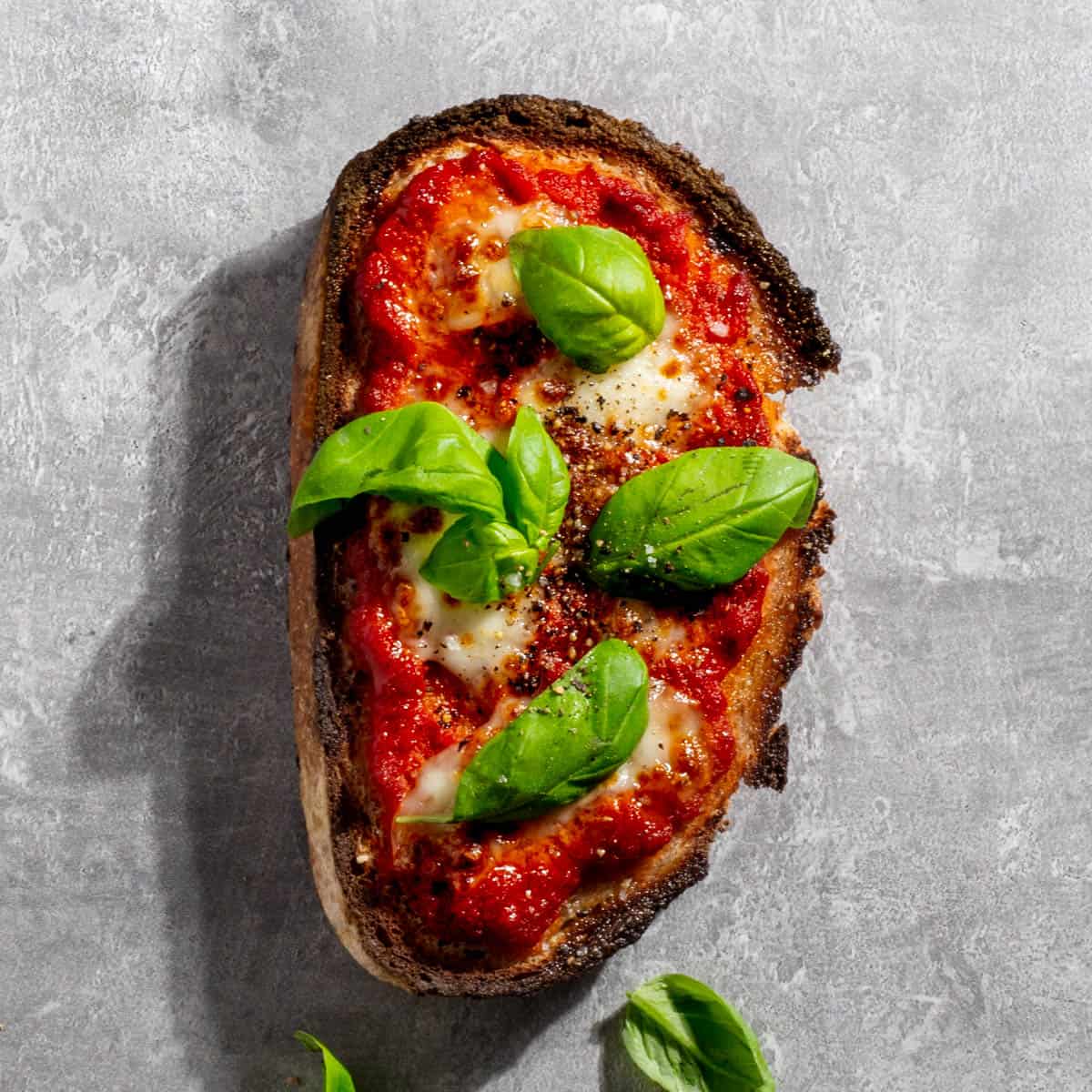 Margherita pizza toast on a grey background.