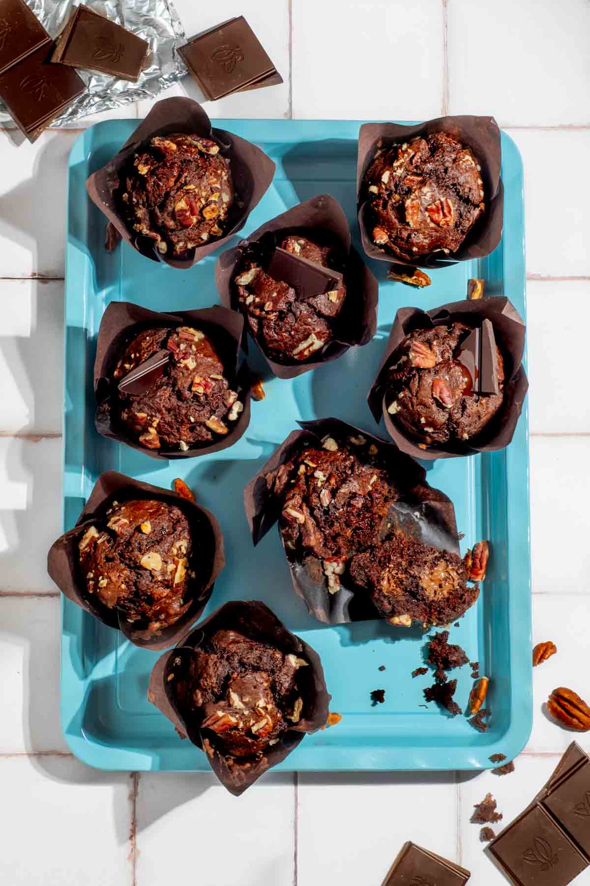 Banana chocolate chunk muffins on a turquoise baking tray.