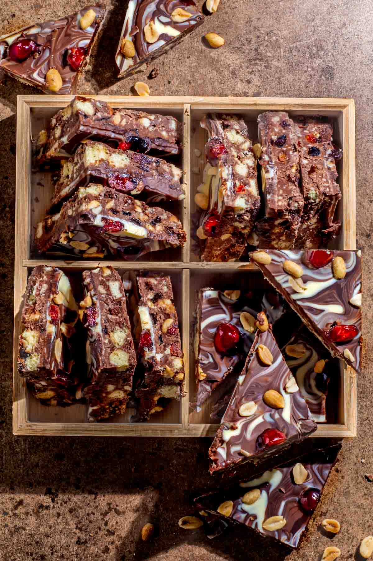 Triangles of chocolate tiffin in a square wooden box.