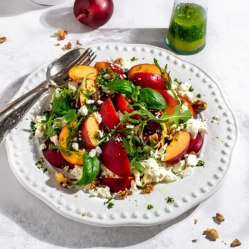 Nectarine salad on a large white plate.