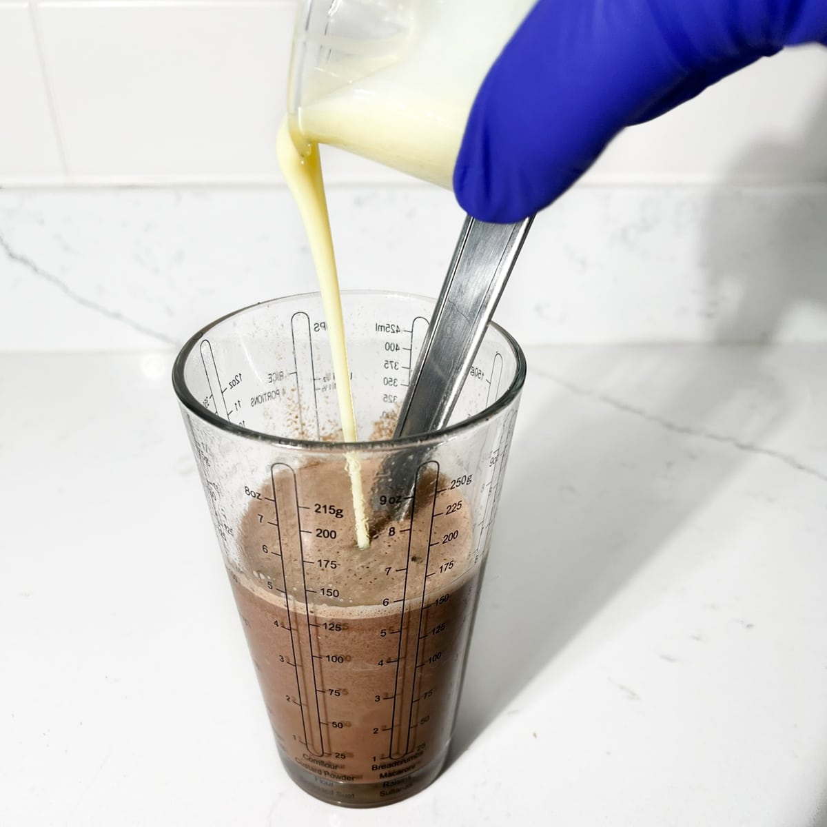 Pouring condensed milk into the milo-dinosaur.