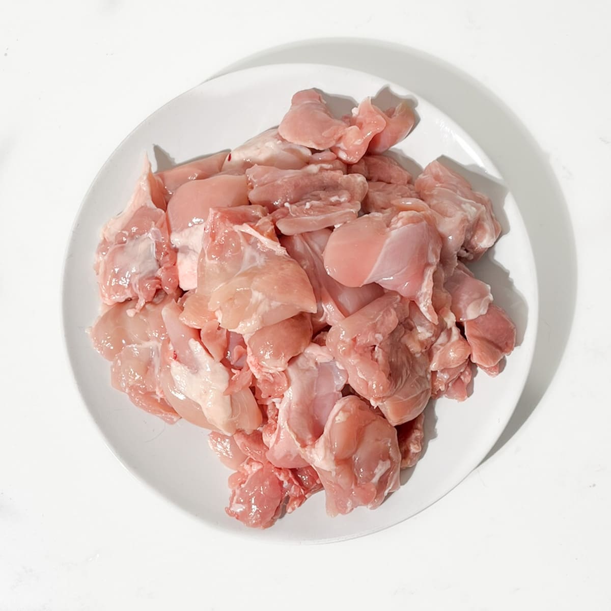 Dicing the chicken thighs into large chunks.