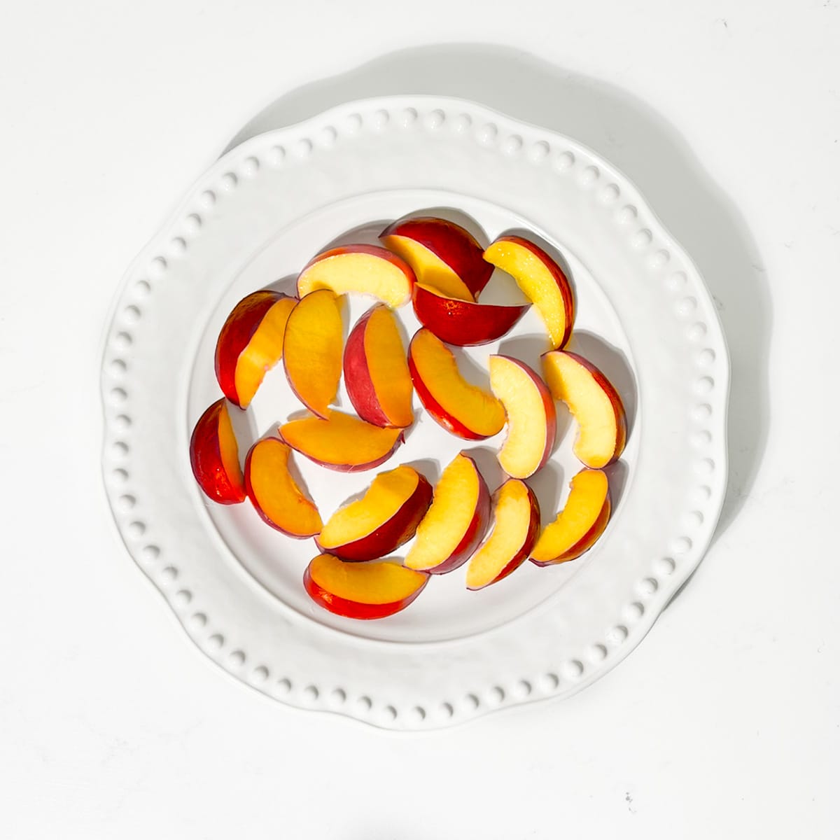 Layering nectarines on a plate for the nectarine salad.