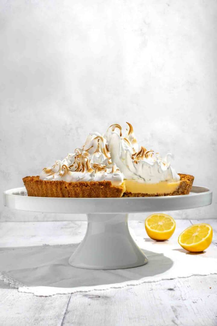 Biscuit base lemon meringue pie on a cake stand.