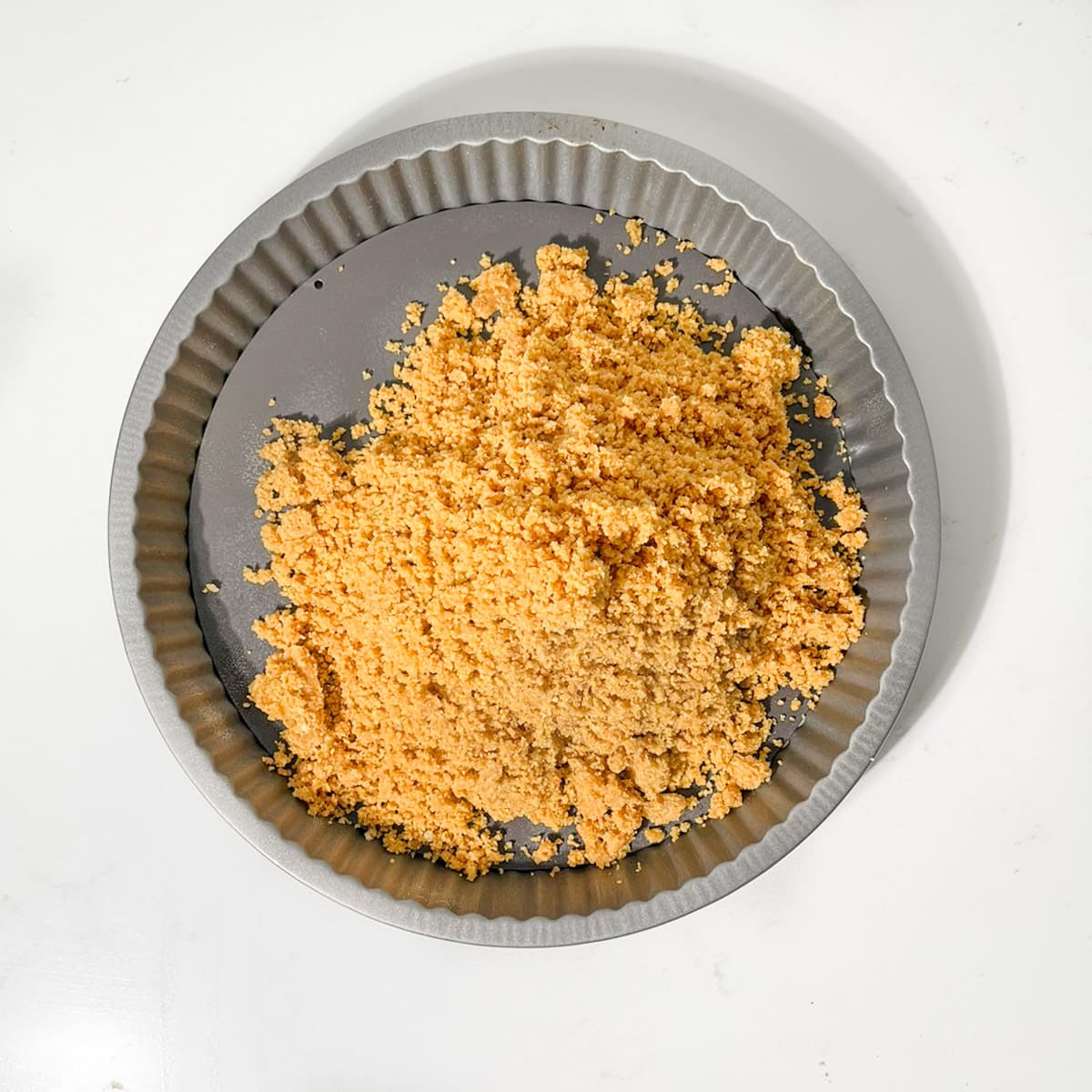 Biscuits crumbs in a tart pan.