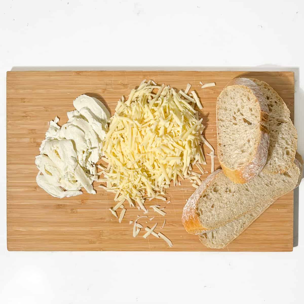 Grated and sliced cheese and bread for the sourdough grilled cheese sandwich.