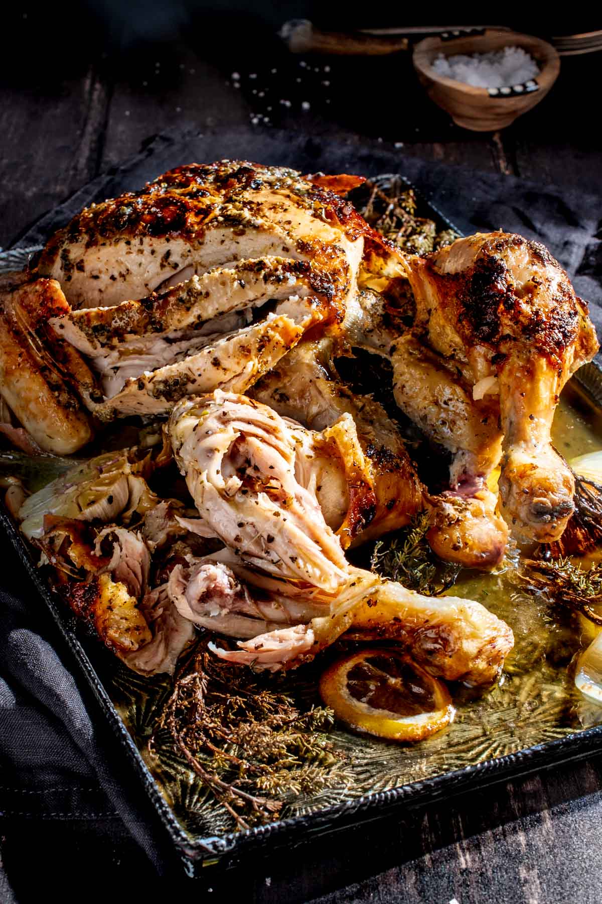 Sliced Greek roast chicken on a baking tray.