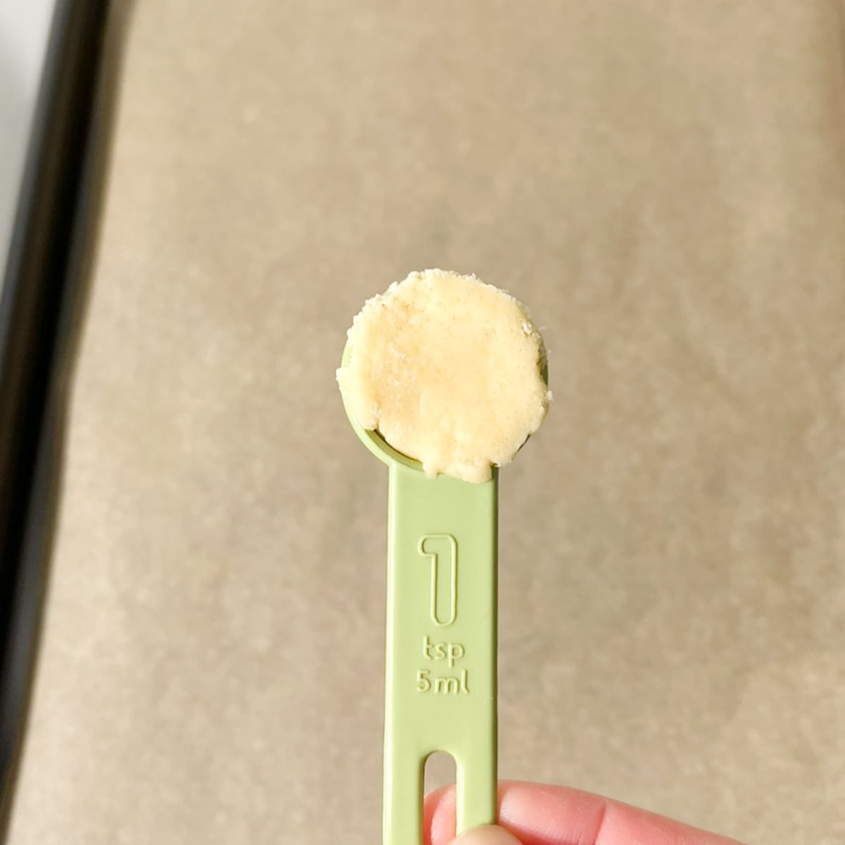 One teaspoon measuring spoon filled with Casadinho dough.