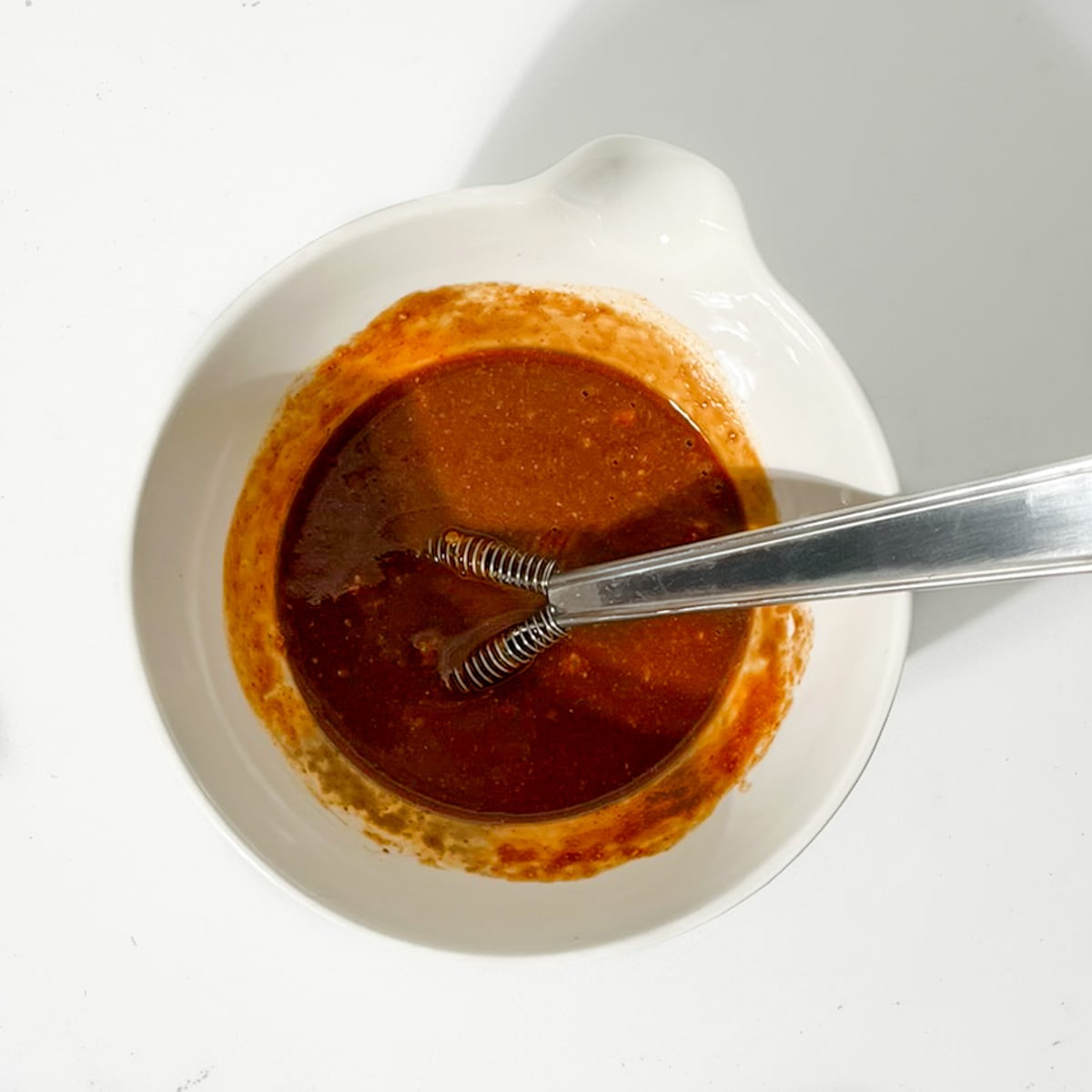 The sriracha sauce ingredients mixed in a small white bowl.