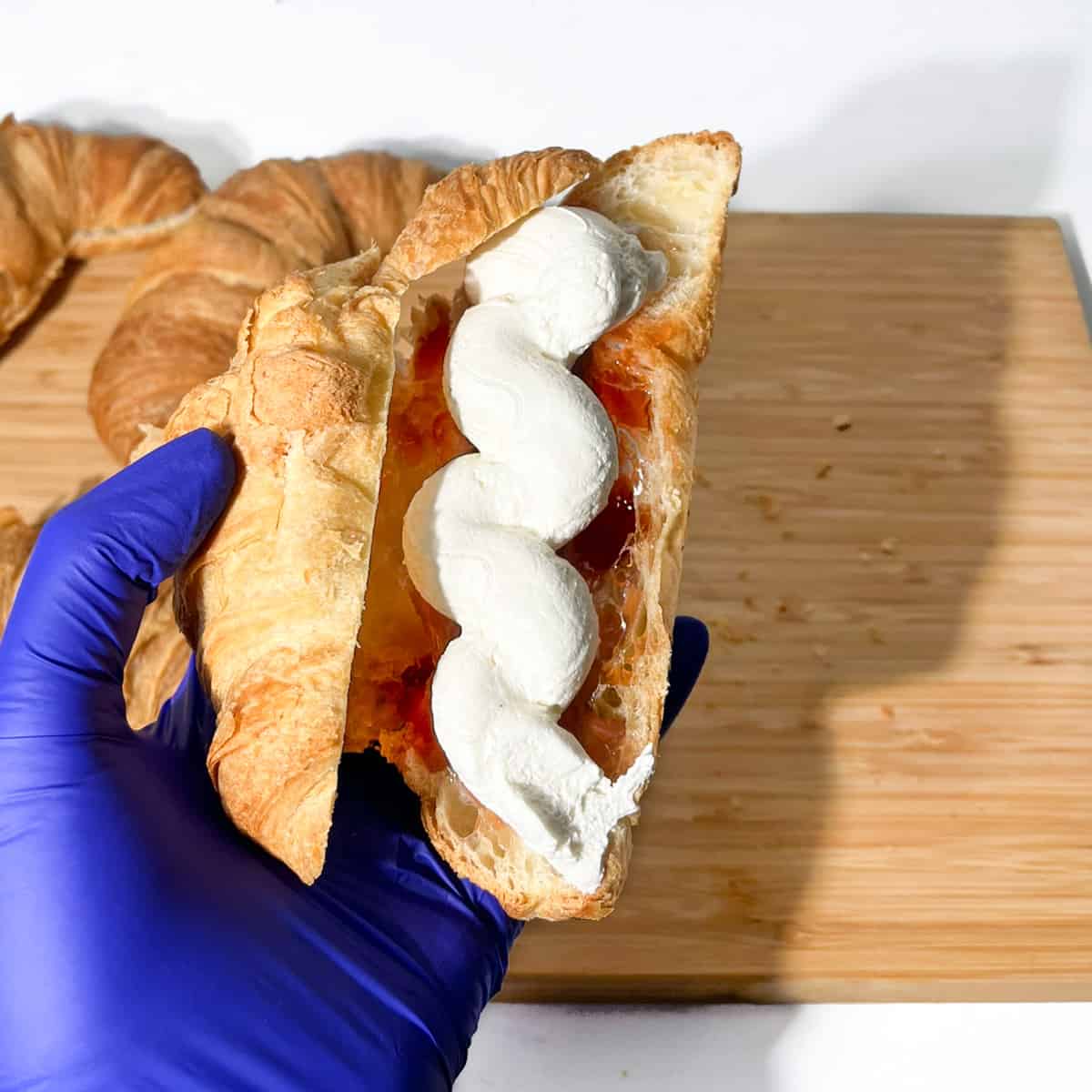 Filling the croissant with the cream.