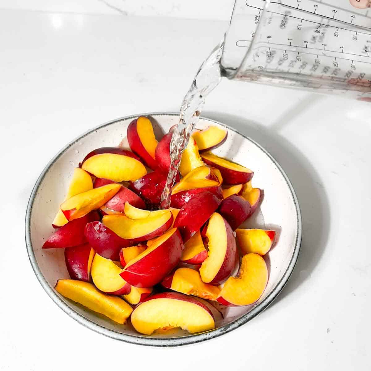 Adding water to the nectarines and lemon juice.