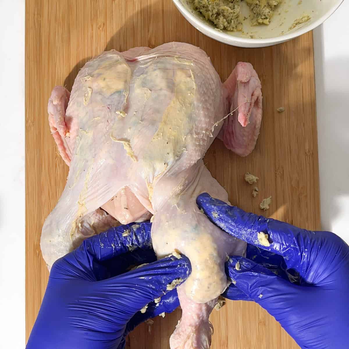 Stuffing compound butter under the chicken leg skin.