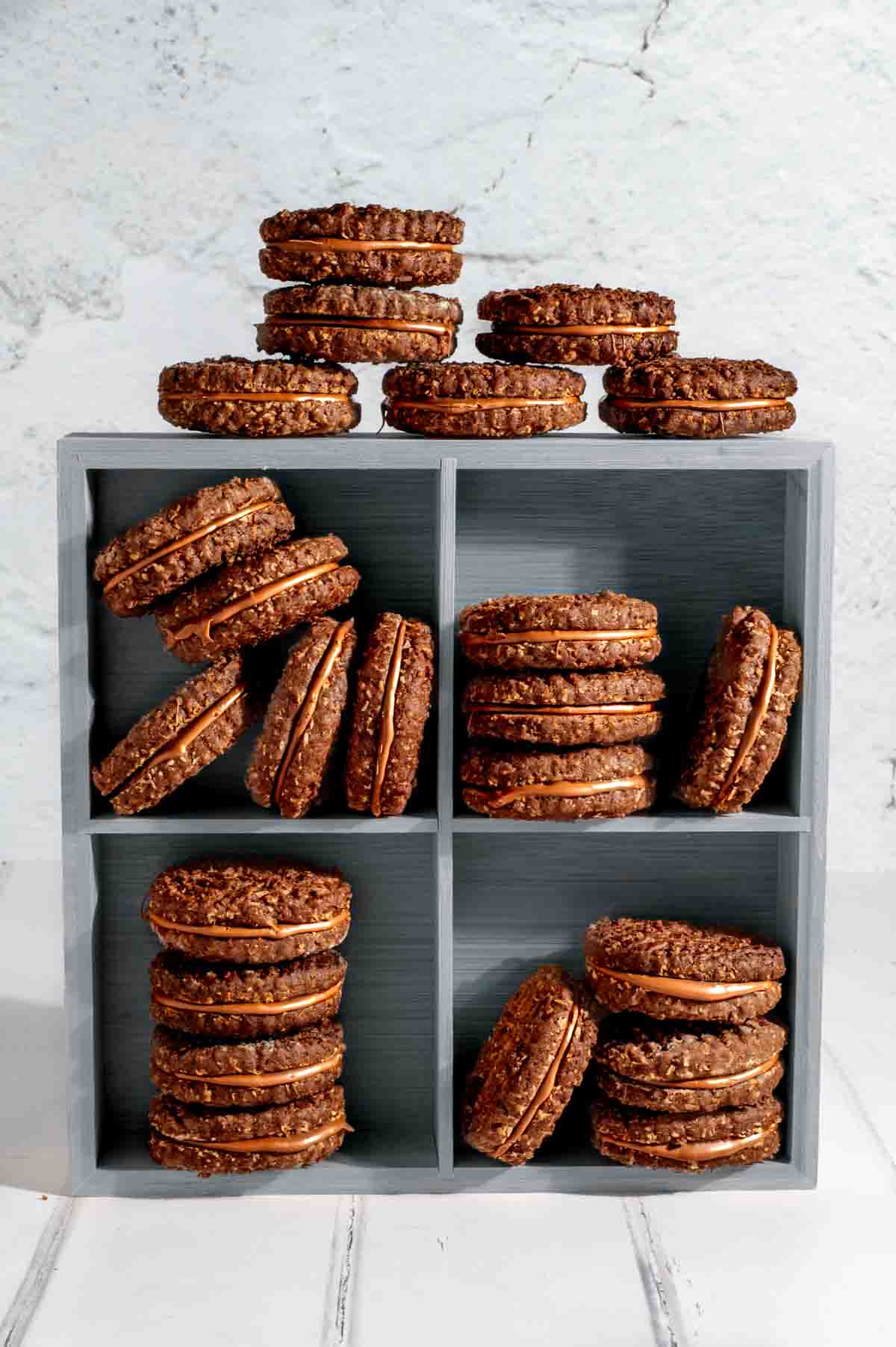 Romany creams stacked on top of each other in an upright wooden box with four compartments.