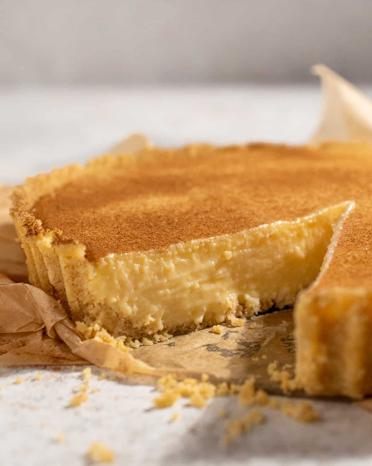 South African milk tart with condensed milk, cinnamon topping and a fluted Tennis biscuit crust.