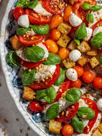 Caprese salad with hot honey dressing on a large oval plate.