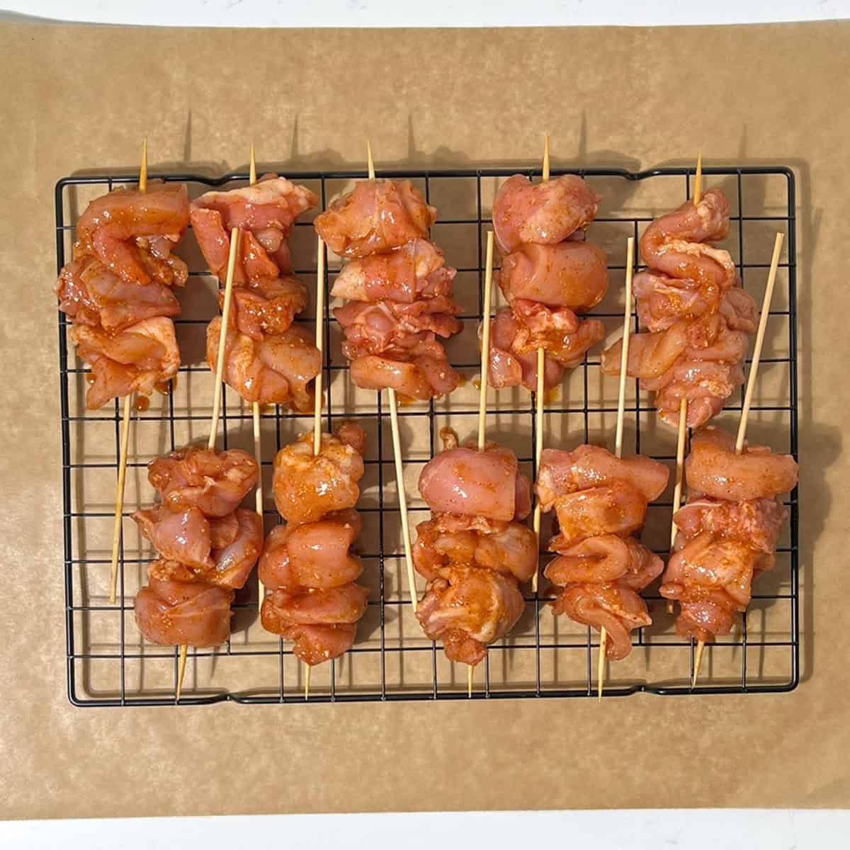 Bang bang chicken skewers on a wire rack.