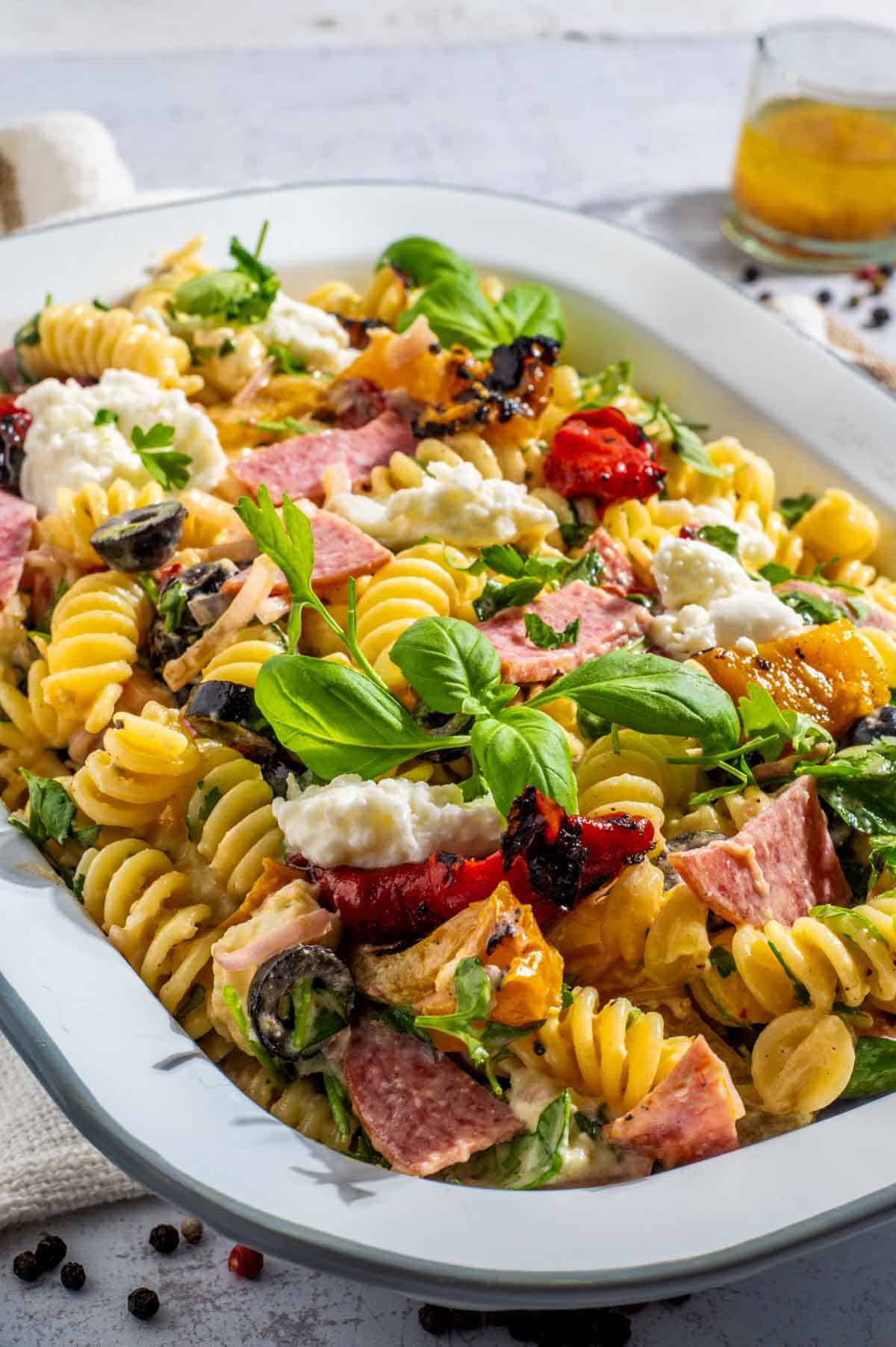 Creamy italian pasta salad in a rectangular enamel bowl.