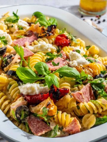 Creamy italian pasta salad in a rectangular enamel bowl.