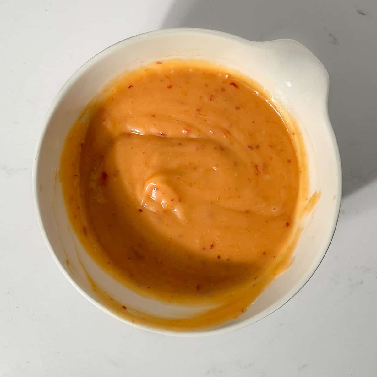 Bang bang sauce in a small white bowl.