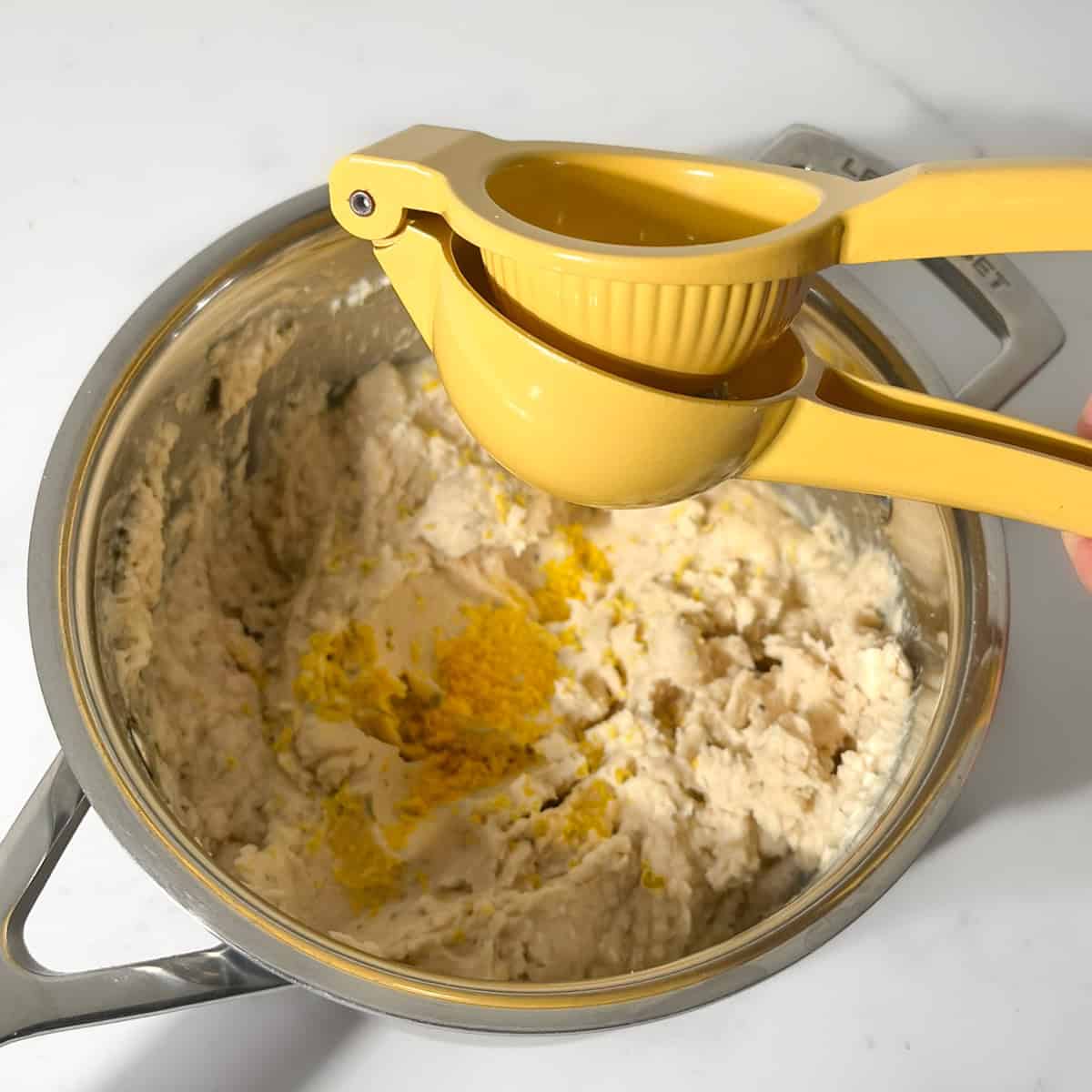Juicing a lemon into the mashed butter beans.