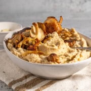 Butter bean mash in a white bowl on a neutral coloured tea towel.