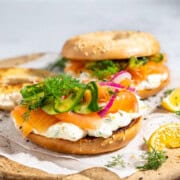 Smoked salmon bagels with whipped cream cheese on a wooden board.