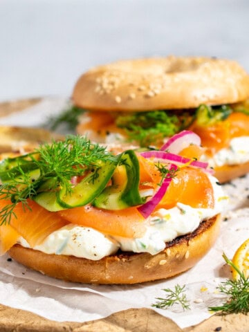 Smoked salmon bagels with whipped cream cheese on a wooden board.