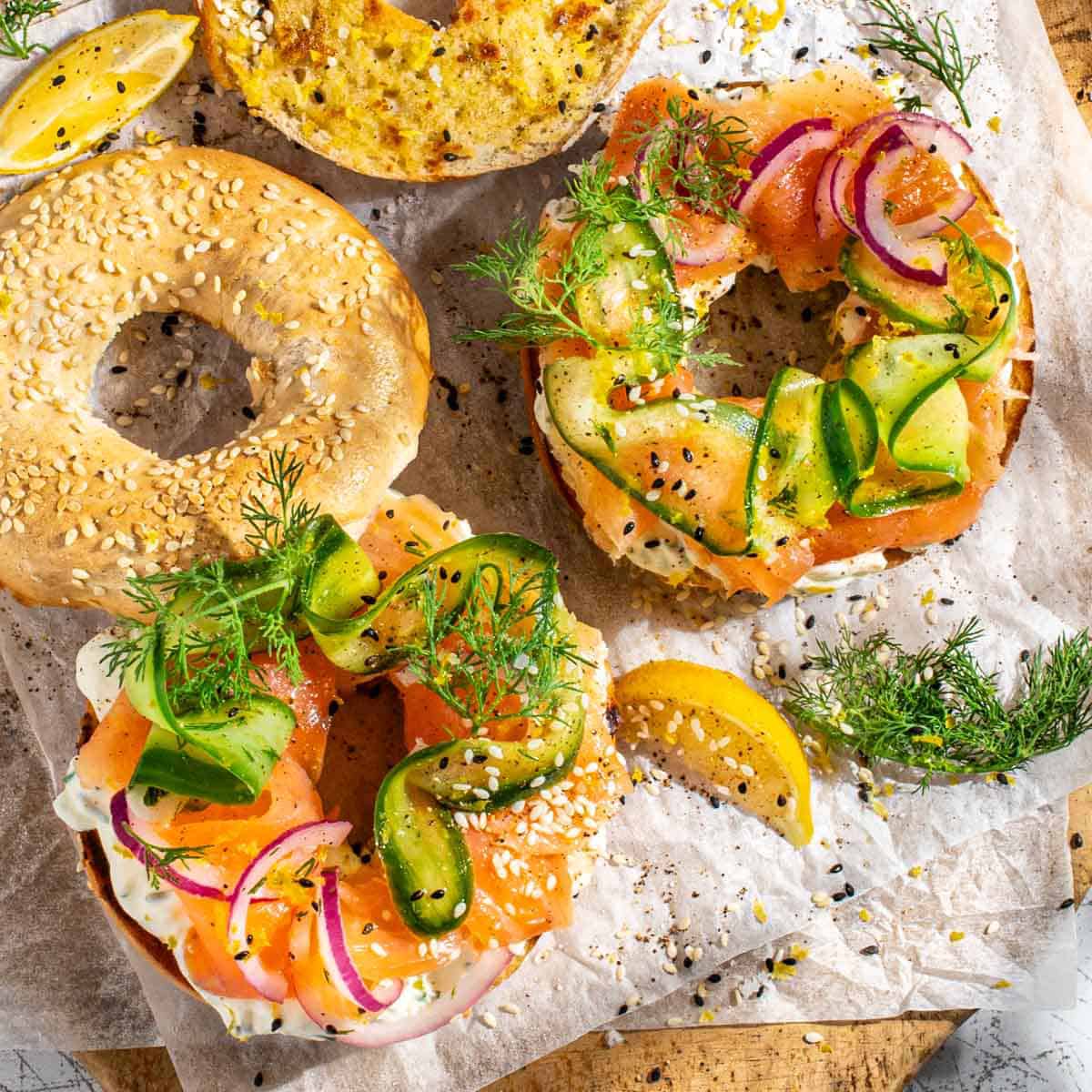 Smoked salmon bagels with whipped cream cheese on a wooden board.