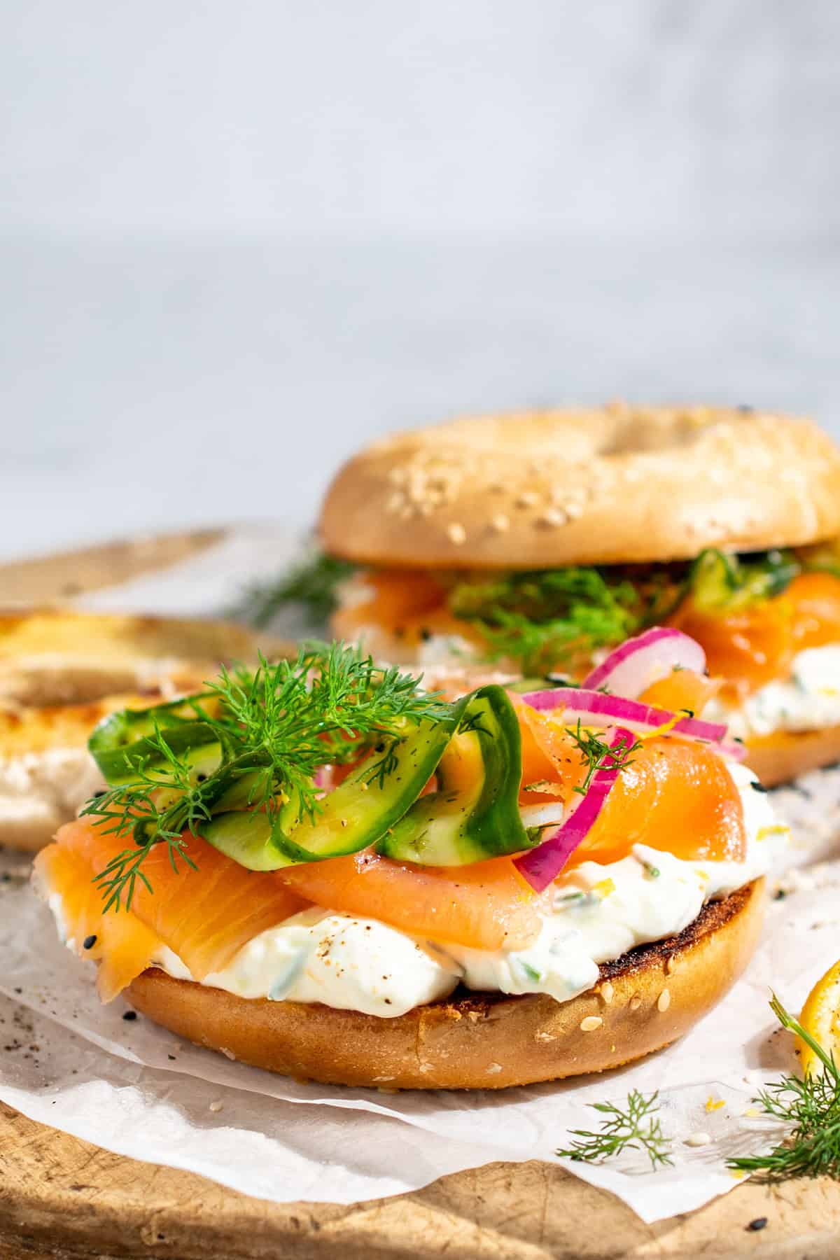 Smoked salmon bagels with whipped cream cheese on a wooden board.