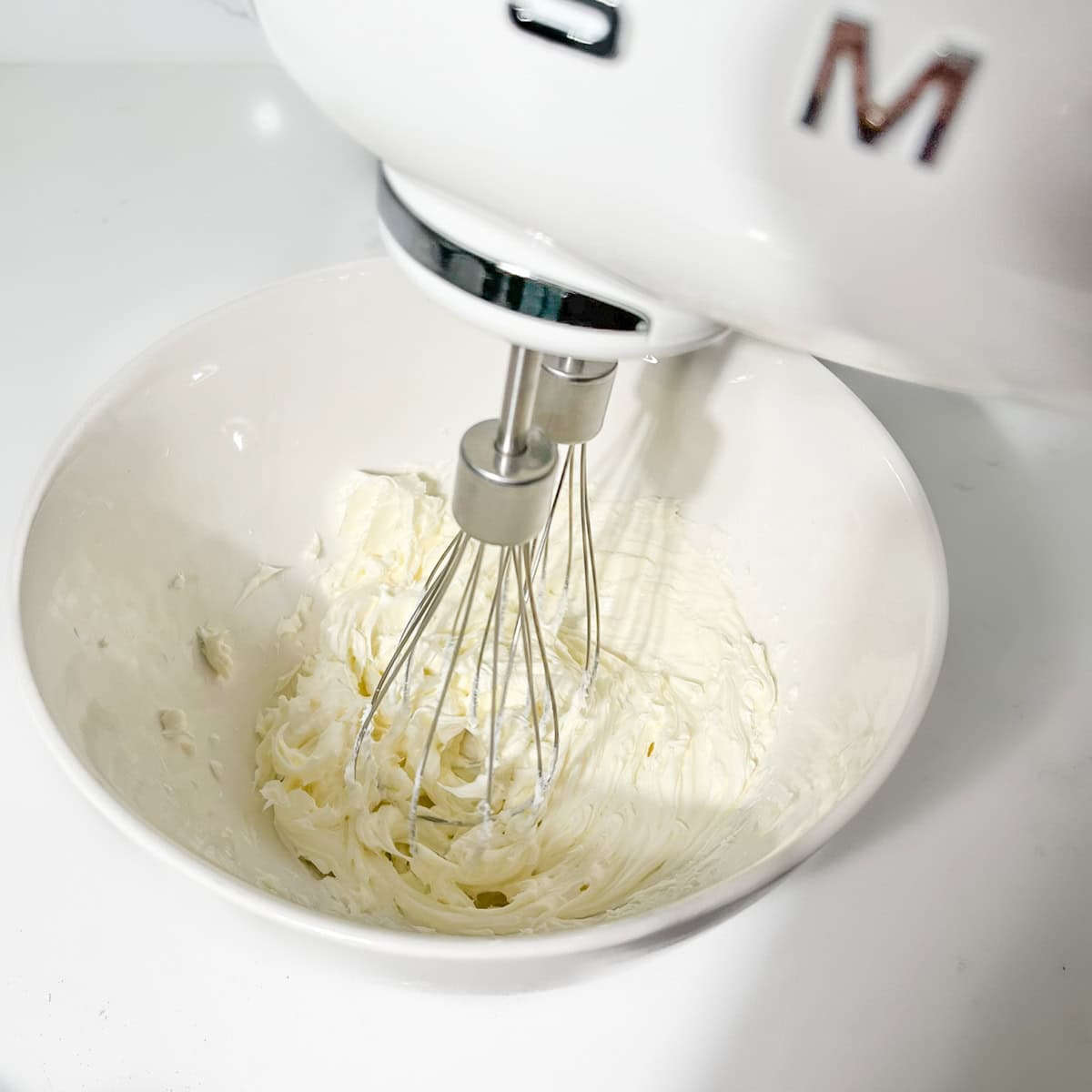 Whipping the cream cheese in a bowl until light and airy.