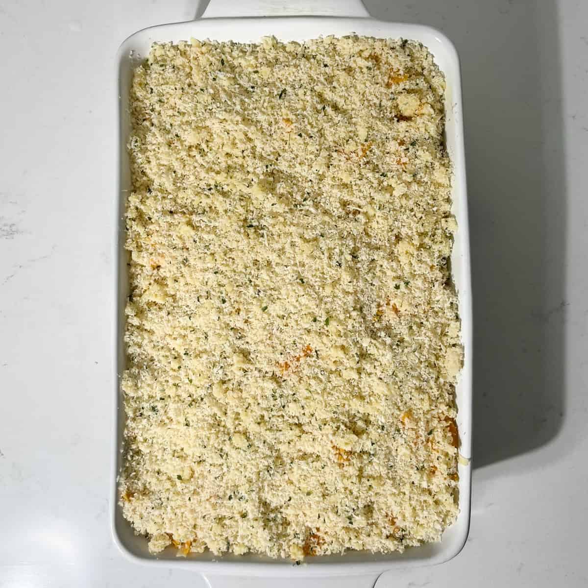 Three cheese baked macaroni and cheese in a large white oven dish, ready to go into the oven.