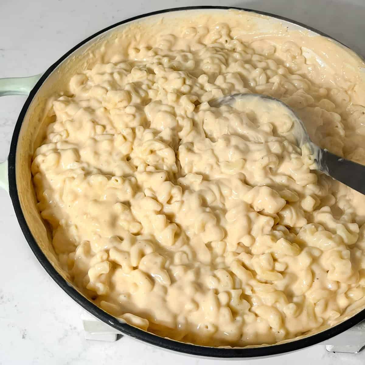 Macaroni and cheese in a large saucepan ready to be transferred to the oven dish.