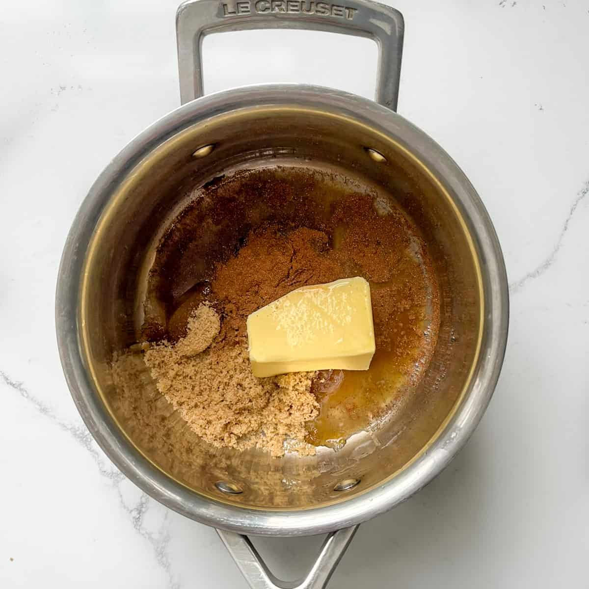 Ingredients for the brown sugar cinnamon butter sauce in a saucepan.