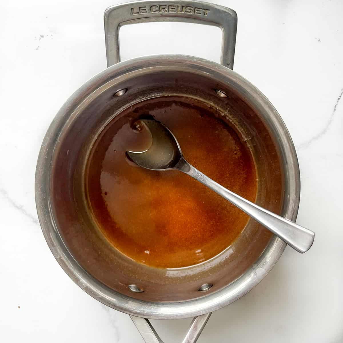 Brown sugar cinnamon butter sauce for the roasted pineapples in a saucepan.
