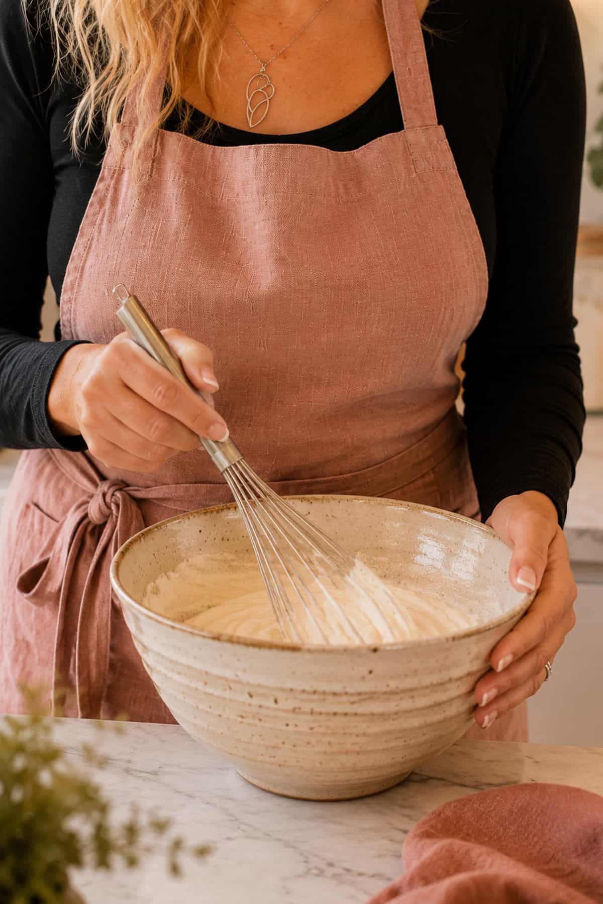 Maretha whisking cream in a large bowl.